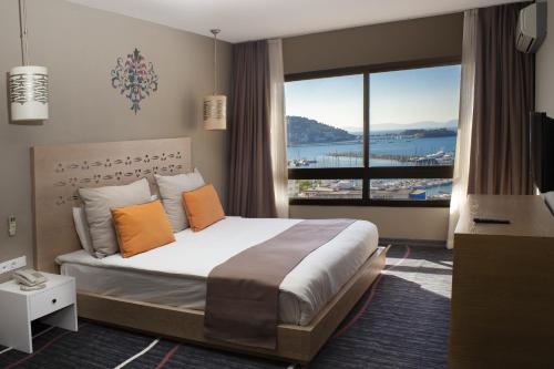 ein Schlafzimmer mit einem großen Bett und einem großen Fenster in der Unterkunft Suhan Seaport 360 Hotel in Kusadası