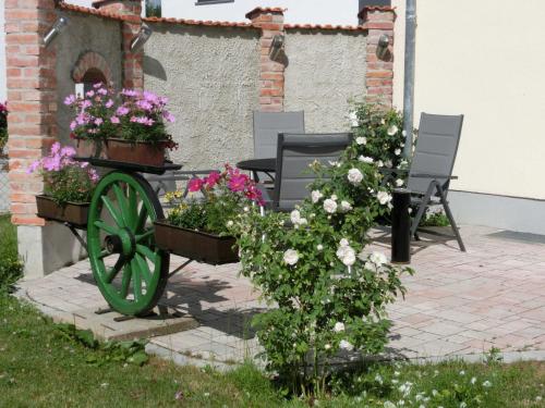 un jardín con dos bancos con flores. en Weberhof, en Egenhofen