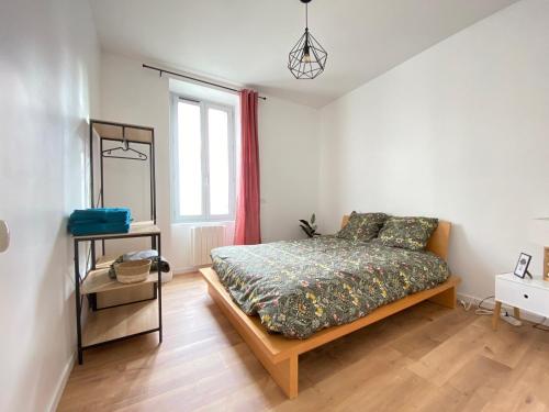 um quarto com uma cama e uma janela em Le Vichatel - Charmant T3 en centre ville proche de place Gaillard em Clermont-Ferrand