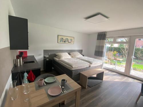 ein Wohnzimmer mit einem Bett und einem Tisch in der Unterkunft Komfort-Apartment BIRKE in Tönisvorst