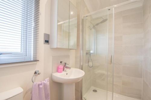 a white bathroom with a sink and a shower at Luxury family Beechwood lodge with hot tub in Lochwinnoch