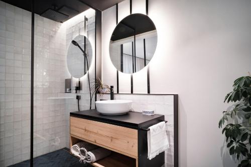 a bathroom with a sink and two mirrors at Grand Pension Franziska - inkl CrossFit Gym in Saalbach Hinterglemm