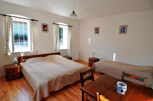 a bedroom with two beds and a wooden table at Kis-Balatoni Ökoporta in Zalaszabar