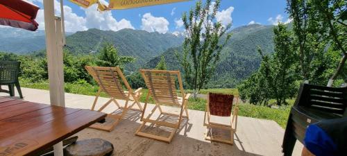 a group of chairs sitting on a patio with a table at Betegi Guest House in Mestia