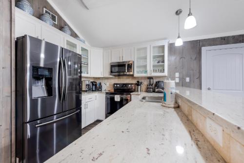 een keuken met witte kasten en een roestvrijstalen koelkast bij Diving Dolphin in Port Aransas