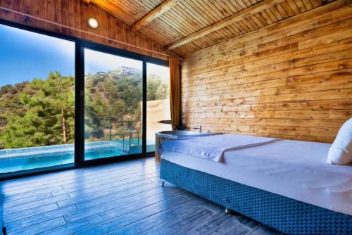 1 dormitorio con cama y ventana grande en Villa Kabak, en Fethiye