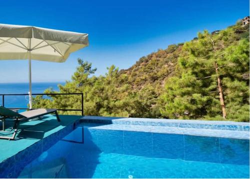 Villa con piscina y sombrilla en Villa Kabak, en Fethiye