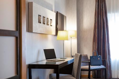 a hotel room with a desk with a laptop on it at Hotel Macià Real De La Alhambra in Granada