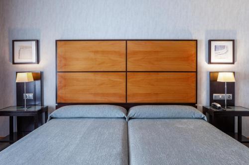 a bedroom with a large bed with a large headboard at Hotel Macià Real De La Alhambra in Granada