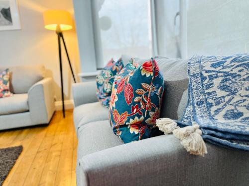 a living room with a couch with pillows on it at Horsforth Lodge in Horsforth