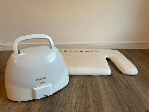 a white toaster sitting on the floor next to a wall at Permai Japon in Nikko