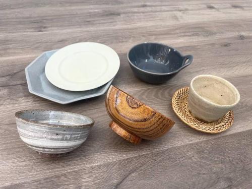 a group of bowls and plates on a wooden table at Permai Japon in Nikko