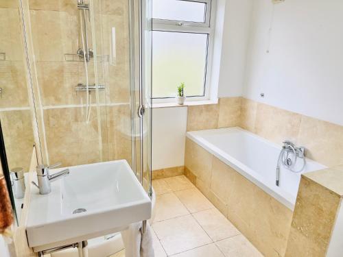 a bathroom with a sink and a tub and a shower at Horsforth Lodge in Horsforth