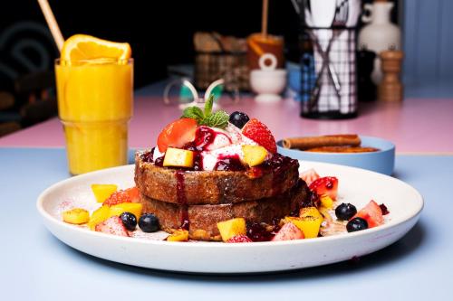 a plate of breakfast food with french toast and fruit at GRANO APARTMENTS Gdańsk Old Town SPA & Wellness - GRANO APARTMENTS Gdańsk Residence SPA & Wellness in Gdańsk