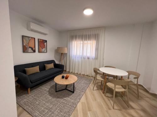 een woonkamer met een bank en een tafel bij Apartamentos Doña Emilia in Adeje