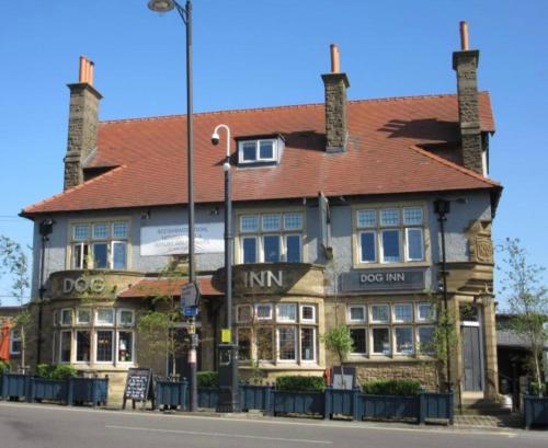 un gran edificio de ladrillo con techo rojo en The Dog Inn en Longridge