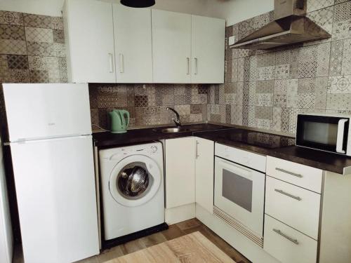 a kitchen with a washing machine and a microwave at Costa del Silencio El Drago in Costa Del Silencio