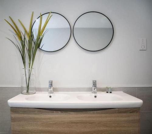 a bathroom with a sink with two mirrors on it at 45a Oxford Street in Harrogate