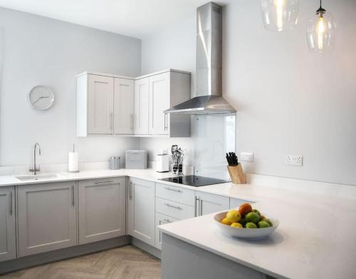 a white kitchen with a bowl of fruit on a counter at 45a Oxford Street in Harrogate