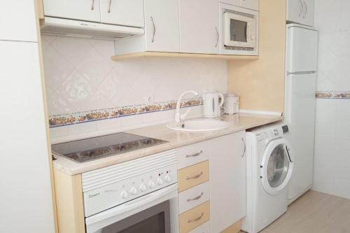 cocina blanca con fregadero y lavadora en Casa Gilda, en Torrevieja