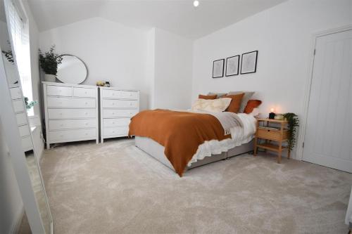 Schlafzimmer mit einem Bett, einer Kommode und einem Spiegel in der Unterkunft 2 bedroom house in Hoylake - Golf Open in Hoylake
