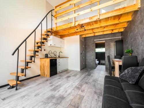 a living room and kitchen with a staircase in a house at Domki SHERWOOD in Gawłowo