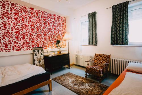 1 dormitorio con 1 cama y 1 silla en Hostel Très Schick en Bamberg