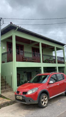 a red car parked in front of a house at Jeitinho da Sô in Tiradentes