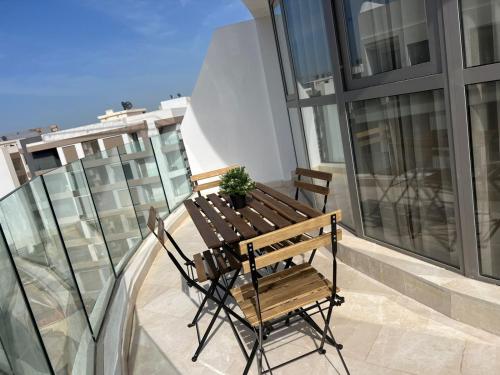 d'une table et de chaises en bois sur un balcon. dans l'établissement New Apartment in Maarif, à Casablanca