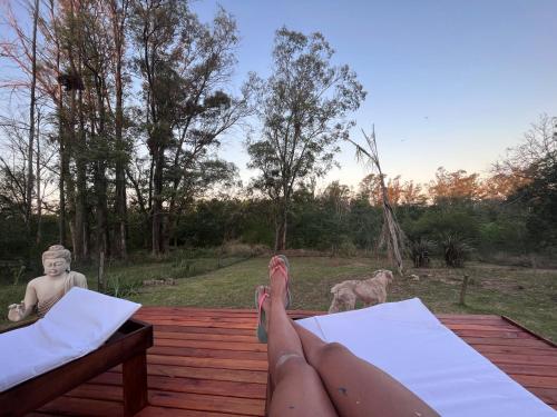 a person with their feet up on a deck with a dog at Mirador del Río in Villa La Rivera