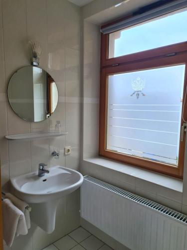ein Bad mit einem Waschbecken und einem Fenster in der Unterkunft Hotel Brauhaus Wittenberg in Lutherstadt Wittenberg