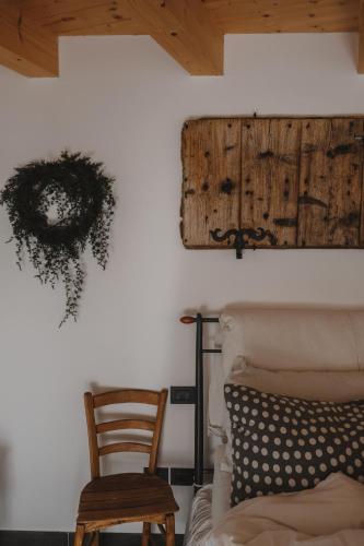 a bedroom with a bed and a wooden chair at Relax in Pineta in Caldonazzo