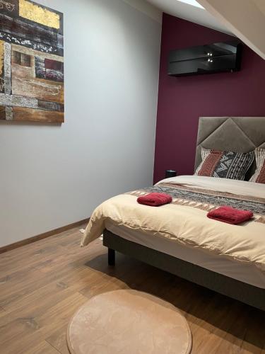 a bedroom with a bed and a purple wall at Gîte en Soi in Montracol