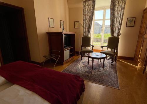 a bedroom with a bed and a table and a window at Hapimag Château de Chabenet in Chabenet