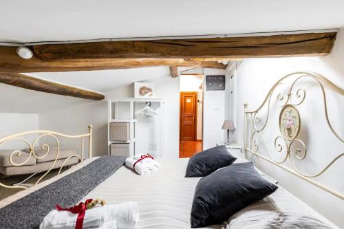 a bedroom with a large bed with black pillows at La Torretta, Decameron View, sweet apartment in Certaldo