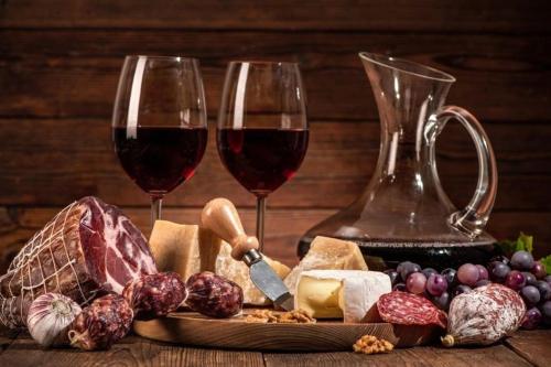 two glasses of red wine next to cheese and grapes at La Torretta, Decameron View, sweet apartment in Certaldo