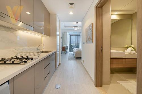 a kitchen with a sink and a stove top oven at Burj Khalifa View Farhad Azizi Residence Al Jaddaf by Venduras in Dubai