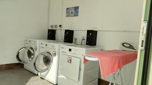 a laundry room with two washing machines and a table at Camping Tikayan Félix de la Bastide in Saint-Mitre-les-Remparts