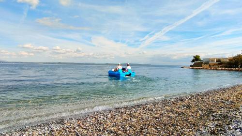 two people on a blue boat in the water at Camping Tikayan Félix de la Bastide in Saint-Mitre-les-Remparts