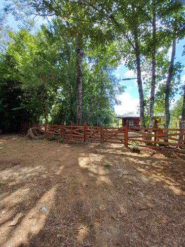 a wooden fence in front of some trees at Cabaña del Volcán in Licán Ray