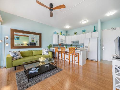 a living room with a green couch and a kitchen at Penthouse With Fabulous Ocean View Near Waikiki Beach in Honolulu