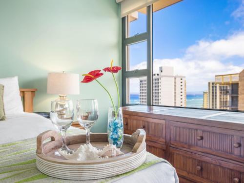 a tray with two wine glasses on a bed with a window at Penthouse With Fabulous Ocean View Near Waikiki Beach in Honolulu
