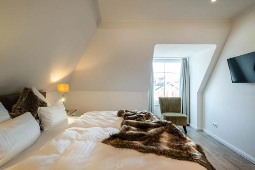 a bedroom with a bed with a blanket on it at Weisse Villa Apartment 3 1 Hafenkante in Büsum