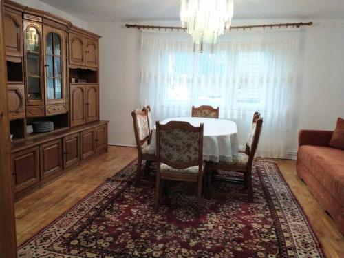 a dining room with a table and chairs and a couch at Casa Livia în inima Bucovinei in Gura Humorului