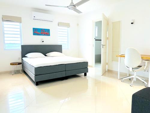 a bedroom with a bed and a table and chairs at Villa Leoni Curaçao in Willemstad