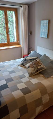 a bedroom with a bed with a checkered bedspread at Nuova Locanda Turisti in Bignasco