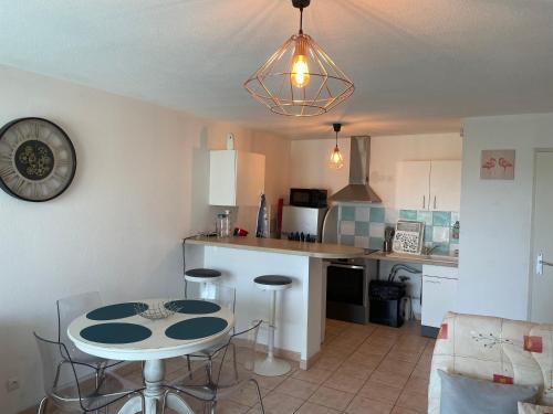 une cuisine avec une table et des chaises dans une pièce dans l'établissement Arles appartement climatisé proche centre-ville, à Arles