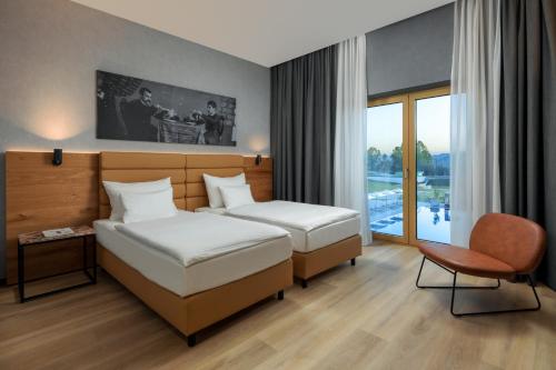 a hotel room with two beds and a chair at mk hotel tirana in Tirana