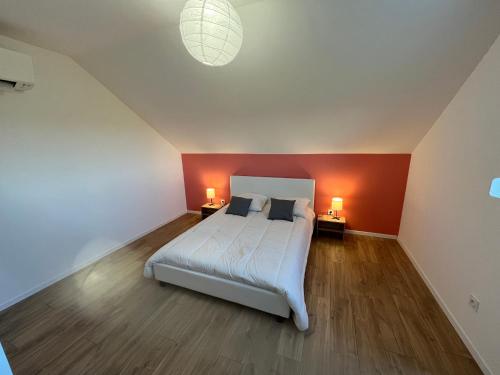 a bedroom with a bed and a red wall at SCI BSA Magnifique maison au calme in Les Essards-Taignevaux