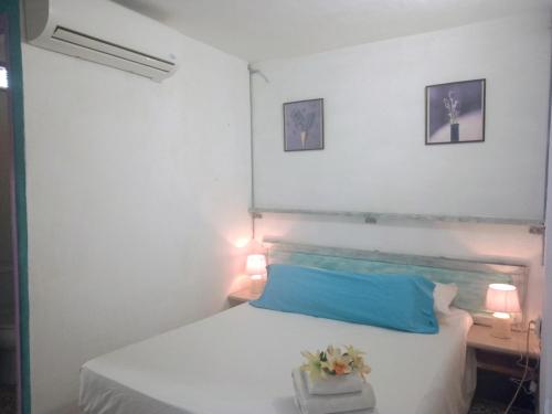 a bedroom with a white bed with a blue pillow at Santa Clara in Almería